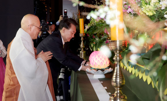 윤석열 대통령이 30일 서울 강남구 그랜드 인터컨티넨탈 서울 파르나스 호텔에서 열린 ‘새해맞이, 나라와 민족을 위한 불교 대축전’에서 한국불교종단협의회 회장 진우 스님과 함께 연등을 공양하고 있다.   2024.1.30  연합뉴스