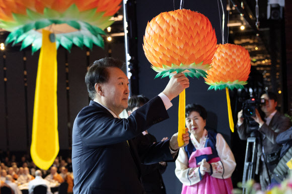 윤석열 대통령이 30일 서울 강남구 그랜드 인터컨티넨탈 서울 파르나스 호텔에서 열린 ‘새해맞이, 나라와 민족을 위한 불교 대축전’에서 한국불교종단협의회 회장 진우 스님, 주현우 한국대학생불교연합회 회장과 함께 신년 발원지를 연등에 달고 있다.  2024.1.30   대통령실 제공