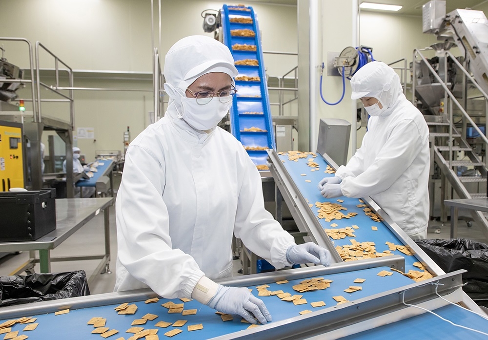 전남 여수에 있는 식품기업 ‘쿠키아’에서 삼성전자 스마트공장 담당자(오른쪽)와 쿠키아 직원이 두부과자 품질 상태를 점검하고 있다. 삼성전자 제공