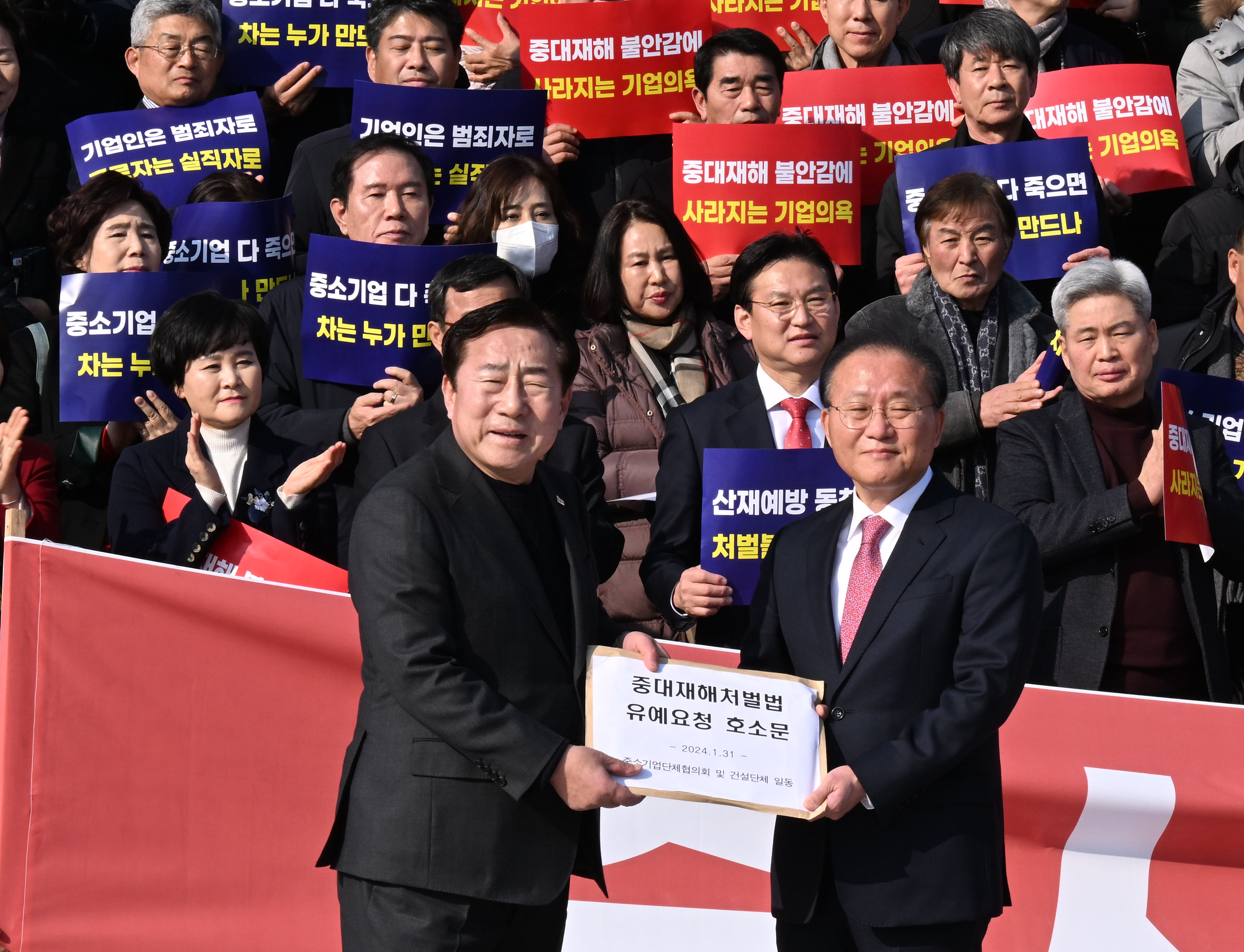 31일 오후 서울 여의도 국회 본청 앞 계단에서 열린 중대재해처벌법 유예 촉구 전국 중소기업인 결의대회에서 김기문 중기중앙회장이 국민의힘 윤재옥 원내대표에게 유예요청 호소문을 전달하고 있다. 2024.1.31 안주영 전문기자