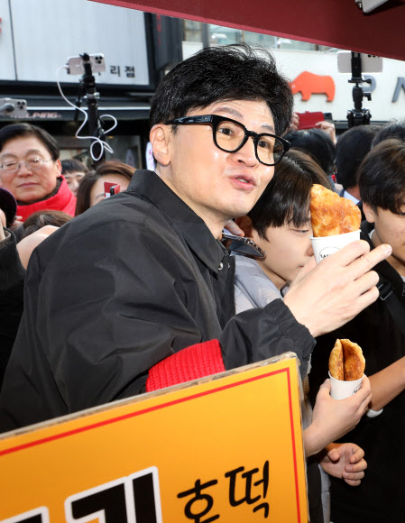 국민의힘 한동훈 비상대책위원장이 설 명절을 앞둔 2일 오후 경기도 구리시 구리전통시장을 방문해 호떡을 구입한 뒤 상인과 대화하고 있다. 2024.2.2  공동취재