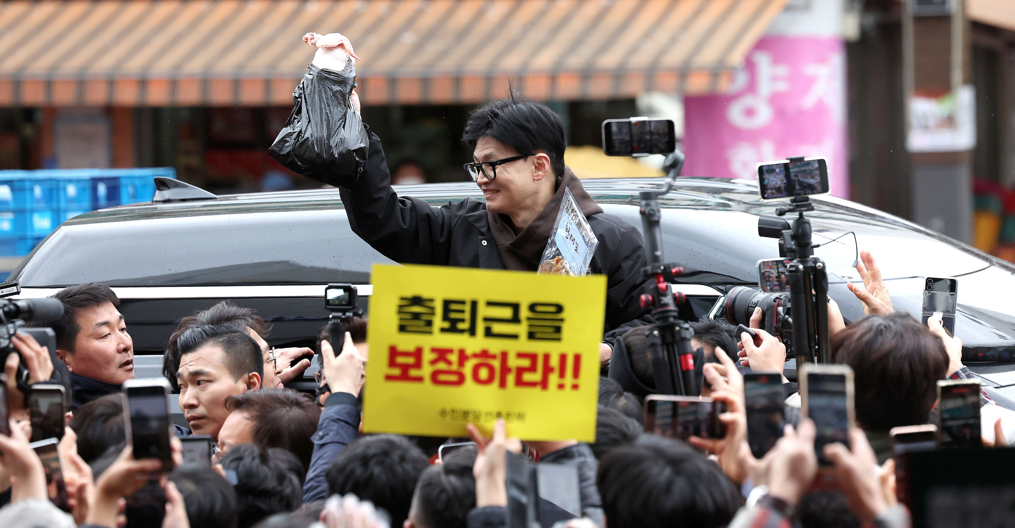 한동훈 국민의힘 비상대책위원장이 설 명절 연휴를 나흘 앞둔 5일 서울 동대문구 청량리 청과물시장·경동시장을 방문해 구매한 상품을 들어보이며 시민들과 인사를 나누고 있다.2024.2.5 안주영 전문기자