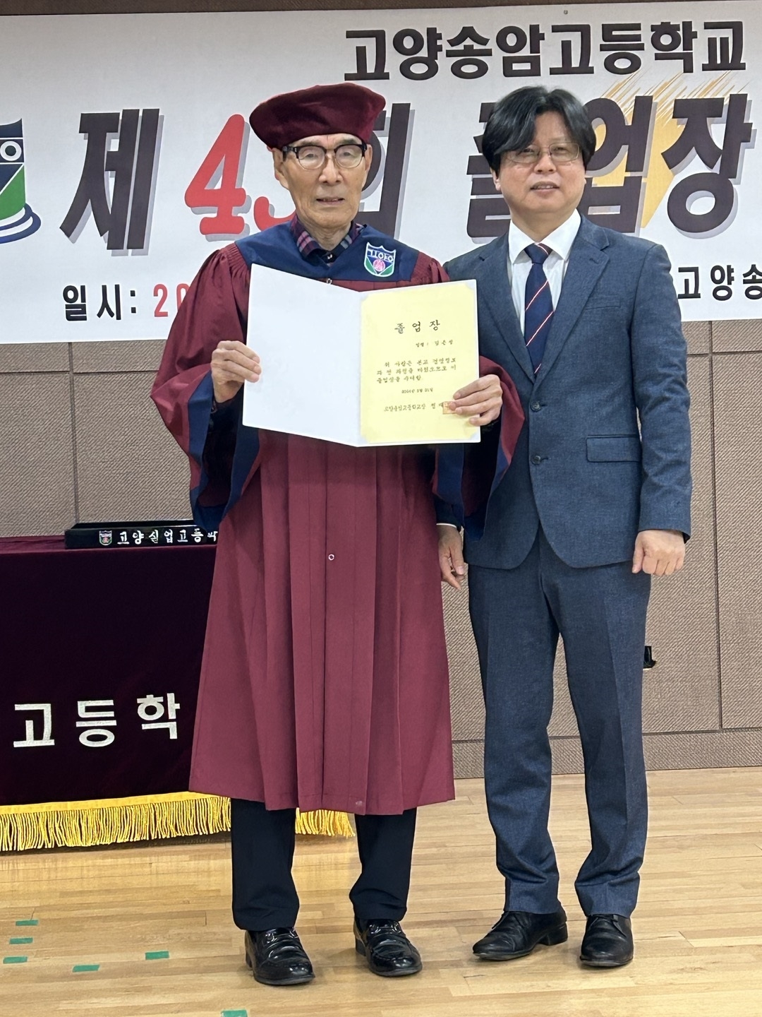 구순의 나이로 오는 21일 고양송암고등학교를 졸업하는 김은성(왼쪽) 할아버지가 정재도 교장과 미리 졸업 사진을 찍고 있다.  고양송암고등학교 제공