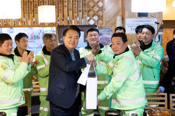 윤석열 대통령이 설 연휴 첫날인 9일 서울 동작구 한 식당에서 동작구 소속 가로청소 환경공무관들과 조찬을 함께하며 설 선물과 시계를 직접 선물하고 있다. 2024.2.9. 대통령실 제공