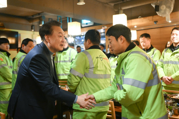 윤석열 대통령이 설 연휴 첫날인 9일 서울 동작구 한 식당에서 동작구 소속 가로청소 환경공무관들과 조찬을 함께하기 전 악수하고 있다.   2024.2.9. 대통령실 제공