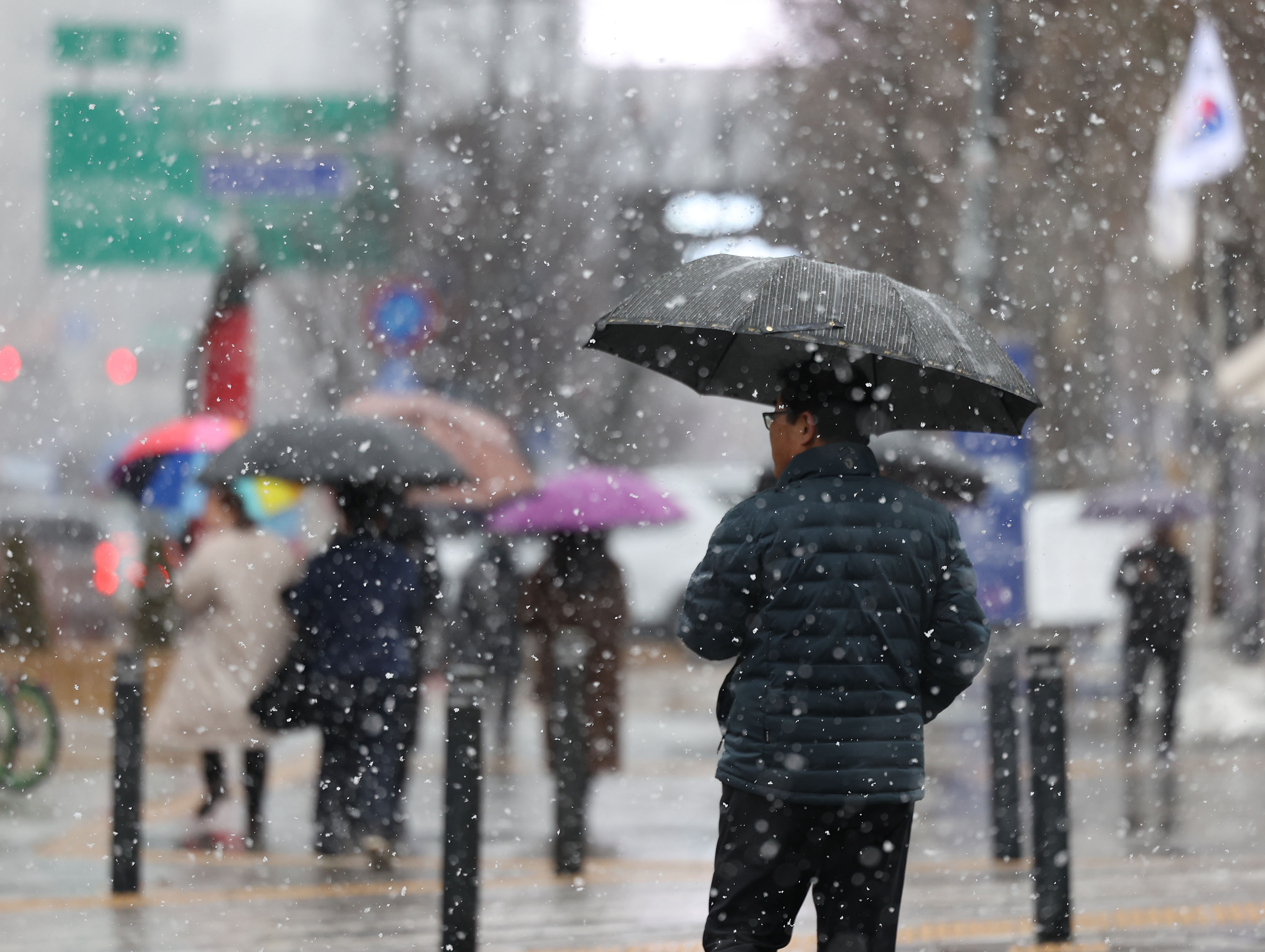 전국 대부분 지역에 비나 눈이 내린 15일 오후 서울 중구 덕수궁인근에서 시민들이 우산을 쓰고 이동하고 있다. 연합뉴스