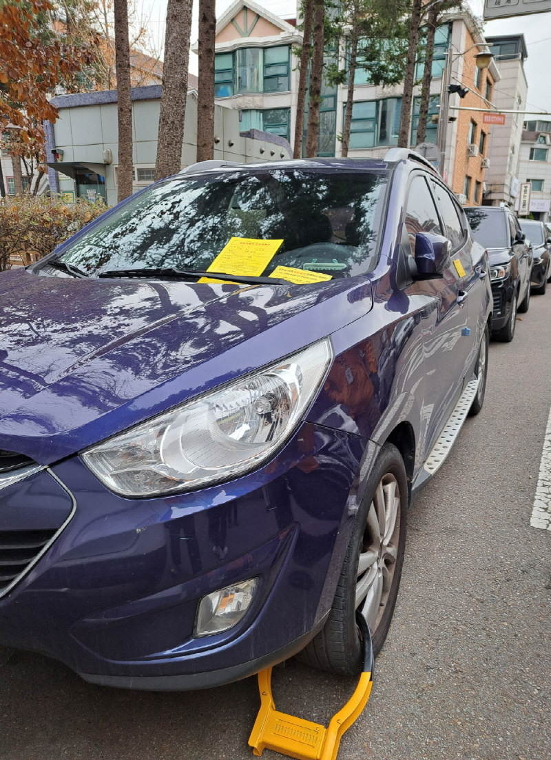 고양시 대포차 단속반원들이 차량 바퀴에 족쇄를 채운 모습. 고양시 제공