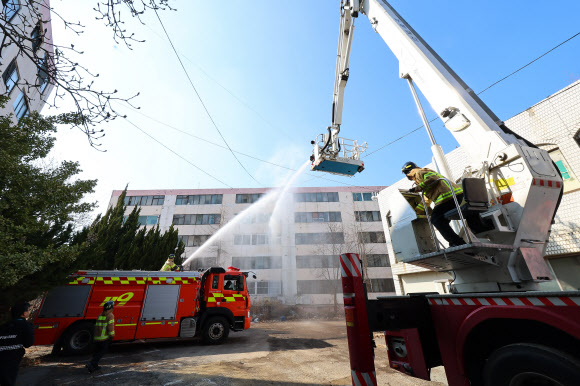 16일 인천 부평구 부개 주택재개발 아파트에서 실시된 재난 현장 대응 실전 소방훈련에서 소방대원들이 방수포 훈련을 하고 있다. 2024.2.16 연합뉴스