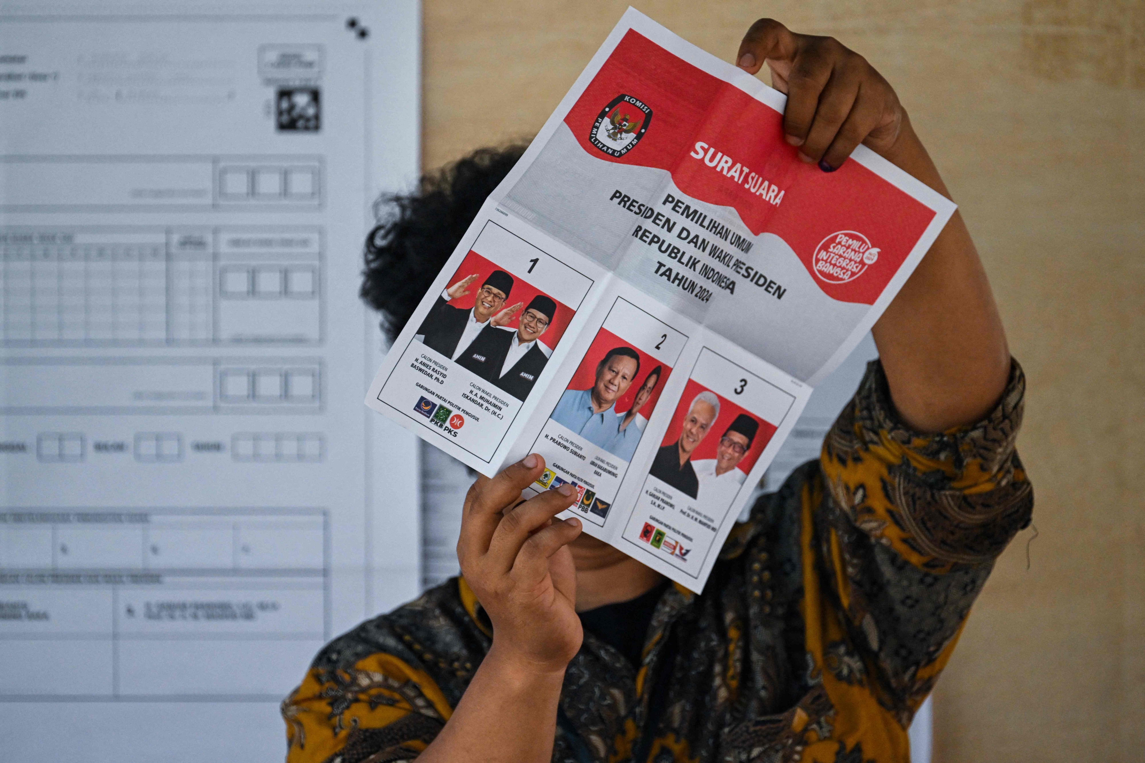 인도네시아의 한 공무원이 14일 인도네시아 수마트라섬 북단에 있는 반다아체에서 열린 인도네시아 대선 및 입법 선거 투표가 끝난 후 투표용지를 들고 있다. 2024.2.14. 반다아체 AFP 연합뉴스