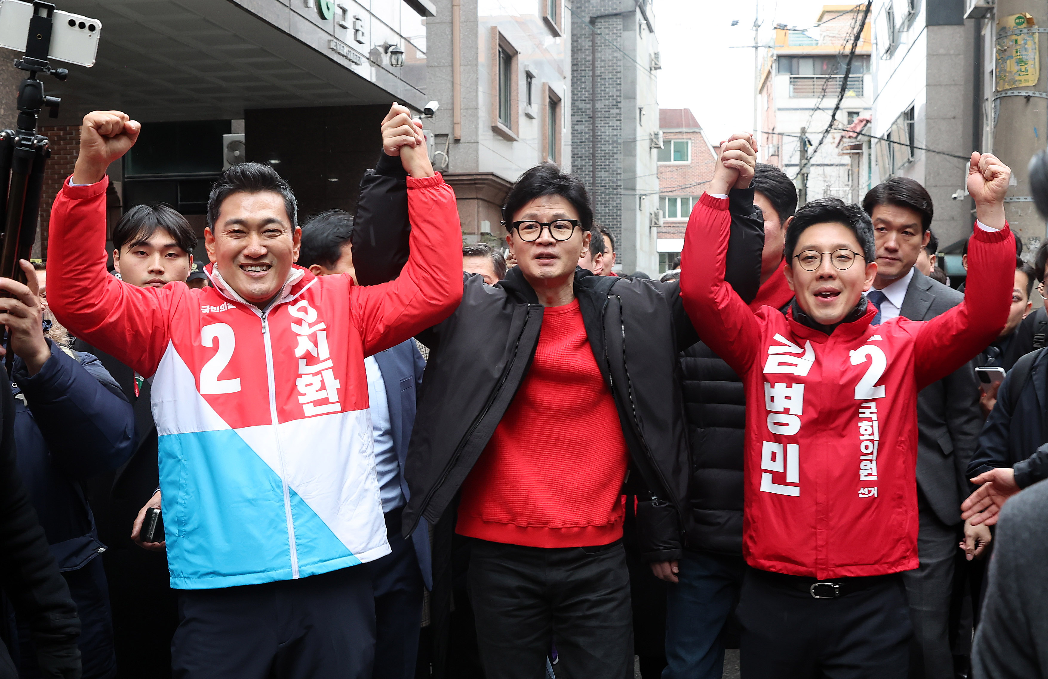 한동훈 국민의힘 비상대책위원장이 20일 오후 서울 광진구 화양동 자율방범대 초소 앞에서 열리는 ‘시민이 안전한 대한민국’ 현장 공약 발표 행사에 앞서 오신환 광진을 후보(왼쪽), 김병민 광진갑 후보와 손을 들어올리고 있다. 2024.2.20 뉴스1