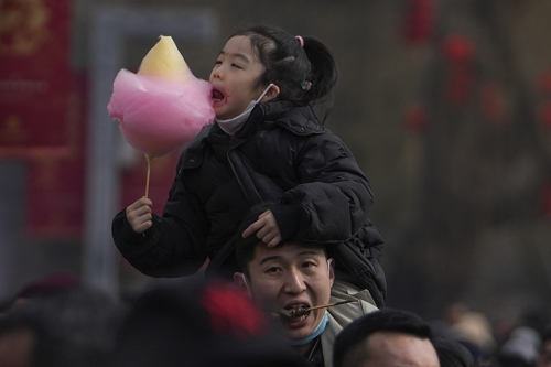 한 중국 남성이 딸을 목마태운채 설 연휴를 즐기고 있다. 베이징 AP 연합뉴스