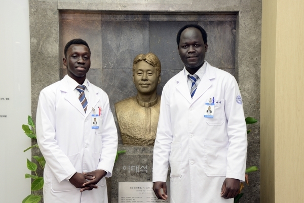 2016년 부산백병원 임상 실습을 받을 당시 이태석 신부 흉상 앞에서 기념 사진을 찍은 토머스 타반 아콧(왼쪽), 존 마옌 루벤. 백병원 제공