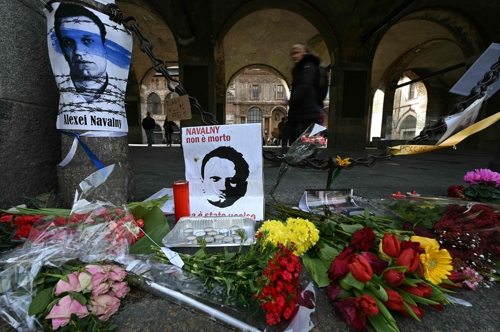 러시아 반정부 활동가 알렉세이 나발니의 포스터 곁에 조화가 24일 놓여 있다. 밀라노 AFP 연합뉴스