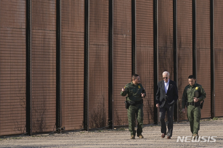 지난해 1월 취임 이후 처음으로 남부 국경지대를 찾은 조 바이든 미국 대통령이 텍사스주 엘패소의 멕시코 국경 장벽을 국경 수비대 대원들과 걸으며 설명을 듣고 있다. 엘패소 AP 뉴시스