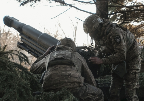 우크라이나 병사가 27일 도네츠크 지역에서 최근 러시아군이 점령 선언을 한 아우디우카를 향해 105㎜ 포를 발사하고 있다. EPA 연합뉴스
