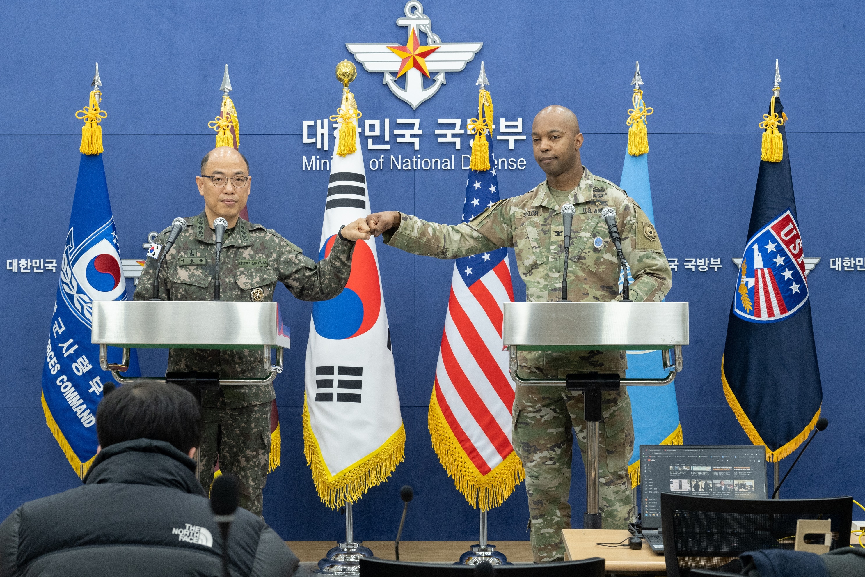 이성준 합동참모본부 공보실장과 아이작 테일러 한미연합군사령부 공보실장이 28일 국방부 브리핑룸에서 열린 합참·연합사 공동 기자회견에서 주먹을 맞대고 있다. 합동참모본부 제공