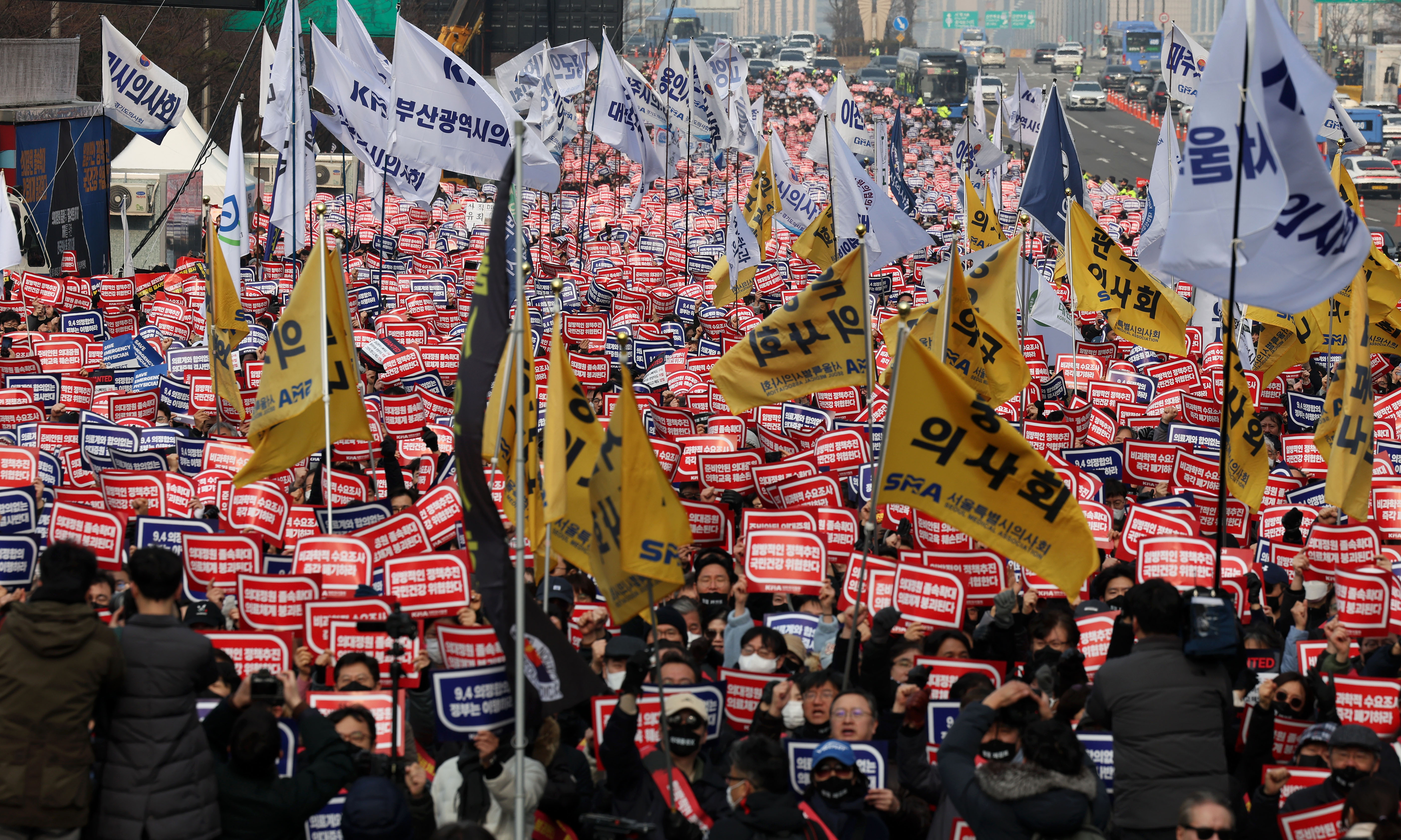3일 서울 영등포구 여의대로에서 열린 의대 정원 증원 및 필수 의료 패키지 저지를 위한 전국 의사 총궐기 대회에서 참석자들이 피켓을 들고 구호를 외치고 있다. 뉴시스