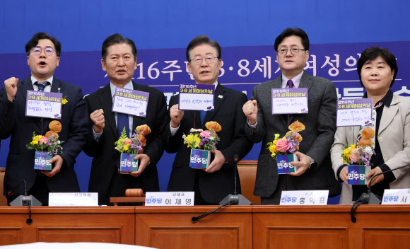 더불어민주당 이재명 대표와 홍익표 원내대표가 8일 국회 당대표회의실에서 열린 3.8 세계여성의날 기념행사에서 기념 메시지를 꽂은 화분을 들고 구호를 외치고 있다. 이 대표는 ‘여성도 행복한 대한민국’이라고 적었다. 2024.3.8 연합뉴스