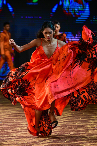 7일(현지시간) 스리랑카 콜롬보에서 열린 콜롬보 패션 위크에서 한 모델이 패션 디자이너 리막의 작품을 선보이다가 넘어지고 있다. AFP 연합뉴스