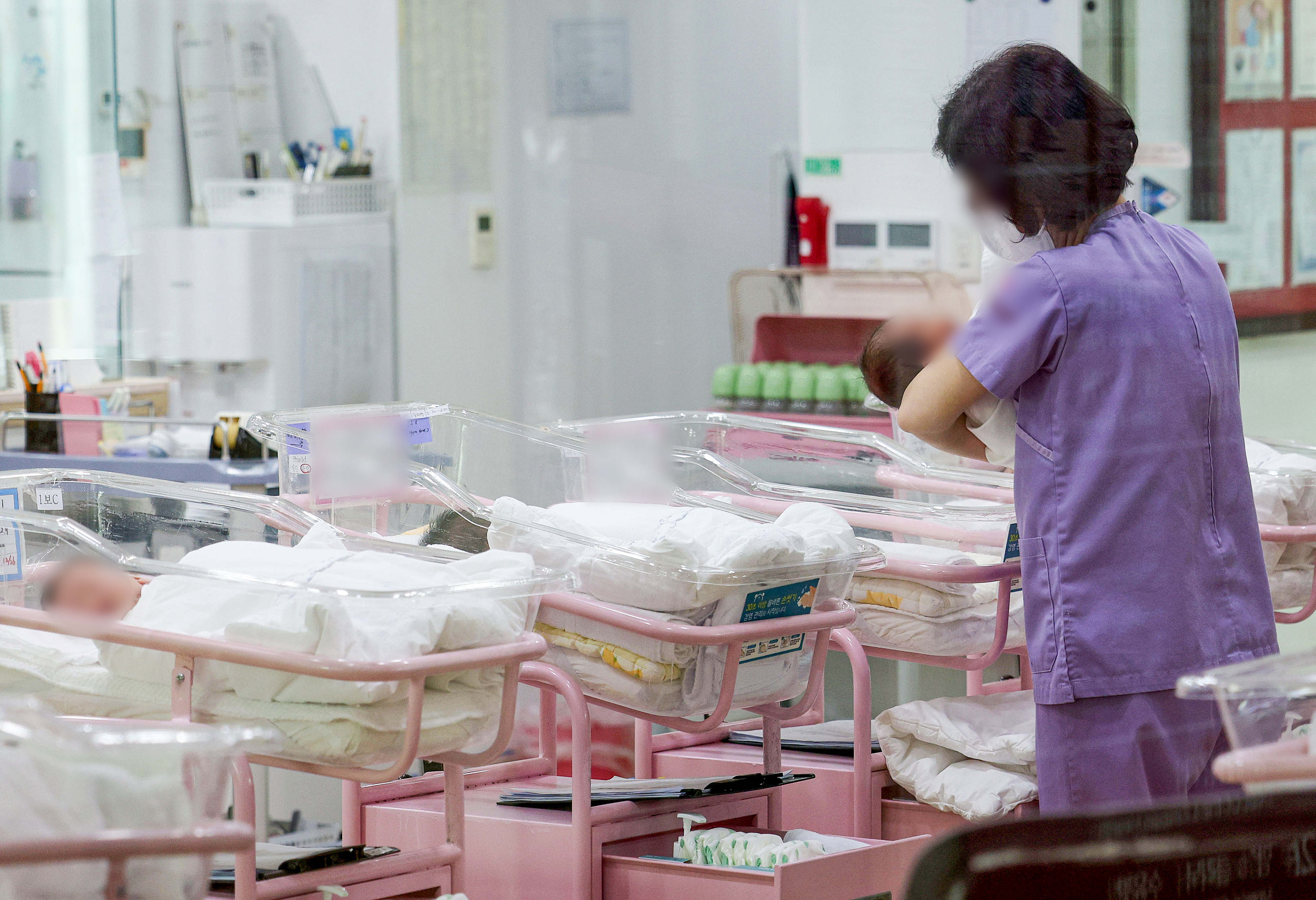 지난달 28일 오후 서울 시내 한 산후조리원 신생아실에서 간호사 등 관계자가 신생아들을 돌보고 있다. 연합뉴스
