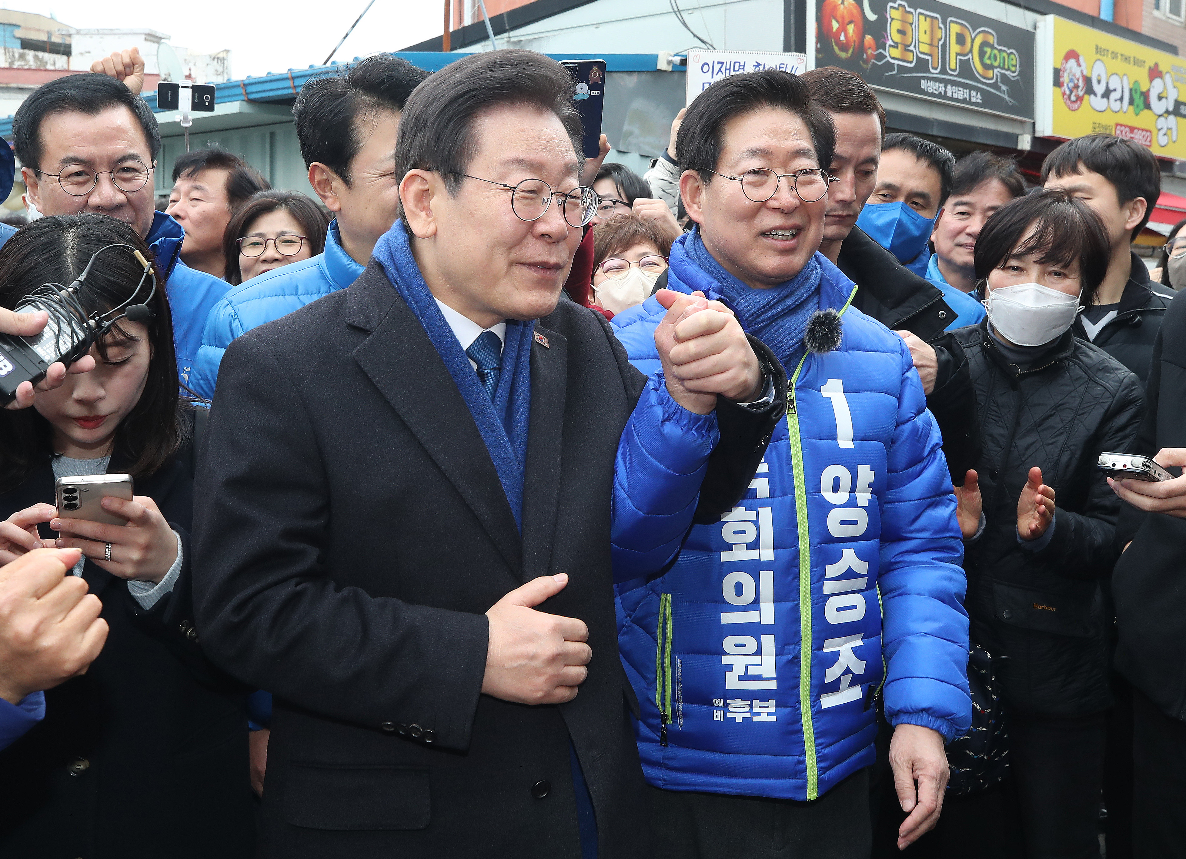 이재명(왼쪽) 더불어민주당 대표가 11일 오후 충남 홍성군 홍성시장을 방문해 양승조 민주당 예비후보의 손을 잡고 시민들에게 지지를 호소하고 있다. 뉴스1