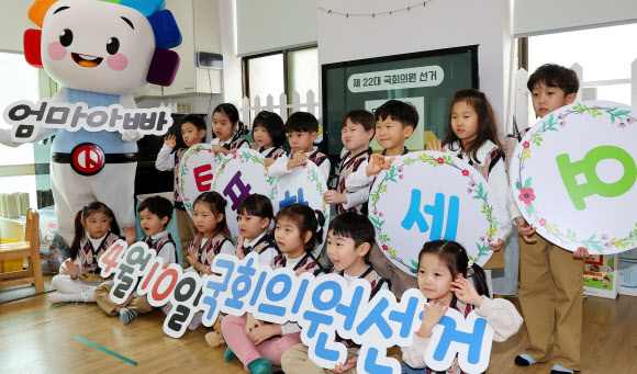 제22대 국회의원 선거를 29일 앞둔 12일 인천 미추홀구 한 유치원에서 인천시선관위 주최로 열린 ‘4월 10일 엄마 아빠 투표해요’ 어린이 모의사전 투표체험에서 어린이들이 피켓을 들고 기념촬영 하고 있다. 2024.3.12 연합뉴스