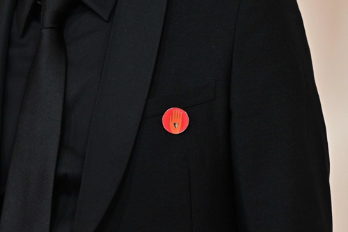 영화 프로듀서 나딤 체이크로우하가 붉은 바탕에 손바닥이 그려져 가자지구 휴전촉구 의미를 담은 핀을 달고 10일 제96회 아카데미 시상식에 참석했다. 로스앤젤레스 AFP 연합뉴스