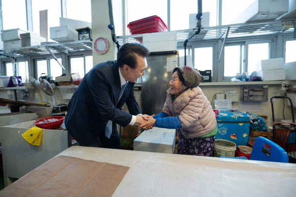 윤석열 대통령이 13일 경남 사천시 삼천포용궁수산시장을 찾아 한 상인과 인사하고 있다. 2024.3.13. 대통령실 제공