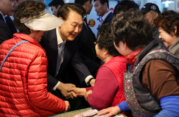 윤석열 대통령이 13일 경남 사천시 삼천포용궁수산시장을 찾아 한 상인과 인사하고 있다. 2024.3.13. 대통령실 제공