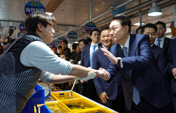 윤석열 대통령이 13일 경남 사천시 삼천포용궁수산시장을 찾아 한 청년 상인을 격려하고 있다. 2024.3.13. 대통령실 제공