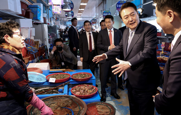 윤석열 대통령이 13일 경남 사천시 삼천포용궁수산시장을 찾아 한 점포에서 수산물을 살피며 대화하고 있다. 2024.3.13 연합뉴스