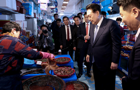 윤석열 대통령이 13일 경남 사천시 삼천포용궁수산시장을 찾아 한 점포를 찾아 문어 등 수산물을 살펴보고 있다. 2024.3.13 연합뉴스