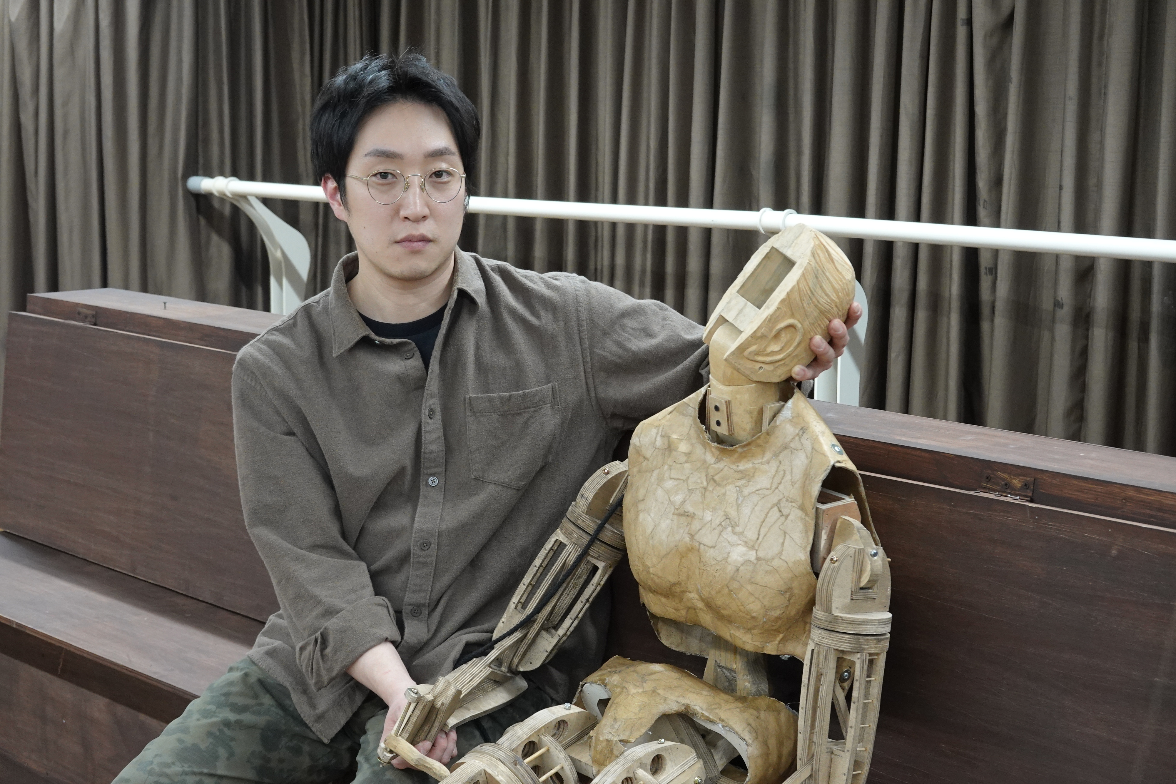 지난 12일 서울 종로구 두산아트센터 연습실에서 만난 인형극 연출가 이지형이 자신이 만든 인형의 목을 받치고 있다. 그는 “관절과 변화의 가능성을 품은 모든 존재는 인형”이라고 했다.