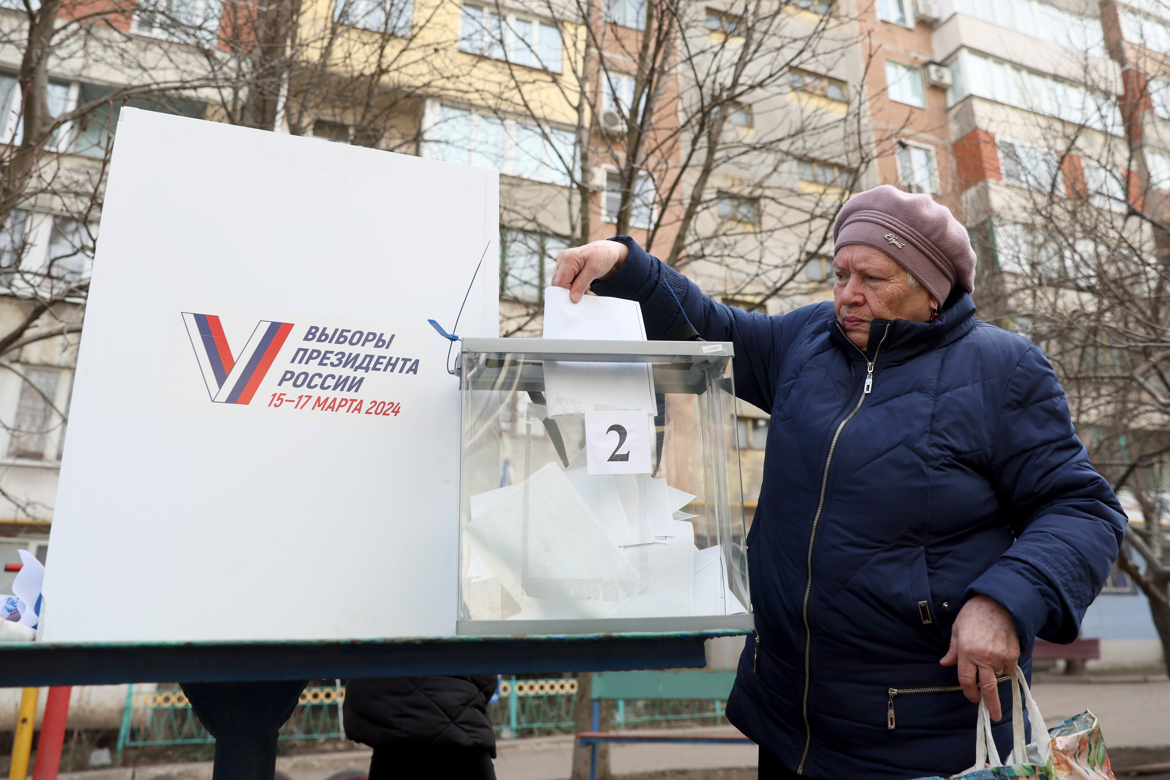 13일(현지시간) 러시아가 점령한 우크라이나 도네츠크주 마키이우카에서 러시아 대통령 선거 사전투표가 진행된 가운데, 한 여성 주민이 투명한 투표함에 용지를 접지 않은 채 넣고 있다. 2024.3.13 TASS 연합뉴스