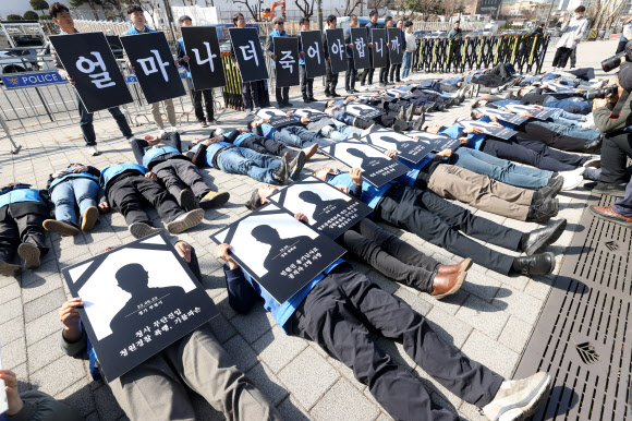 전국공무원노동조합과 대한민국공무원노동조합총연맹 관계자들이 18일 오전 서울 용산구 대통령실 앞에서 열린 ‘공무원 악성민원 대책 마련 촉구 기자회견’에서 ‘악성민원 희생자 추모 다잉 퍼포먼스’를 하고 있다. 2024.3.18 연합뉴스