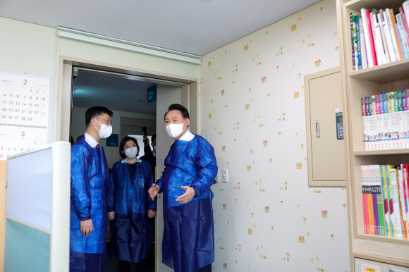 윤석열 대통령이 18일 서울아산병원 어린이병원을 방문해 위생 가운을 착용한 뒤 소아혈액종양병동 내 병원학교에서 병원 관계자의 설명을 듣고 있다. 2024.3.18. 대통령실 제공