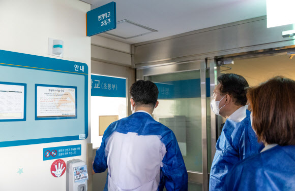 윤석열 대통령이 18일 서울아산병원 어린이병원을 방문해 위생 가운을 착용한 뒤 소아혈액종양병동 내 병원학교로 들어갈 준비를 하고 있다. 2024.3.18. 대통령실 제공