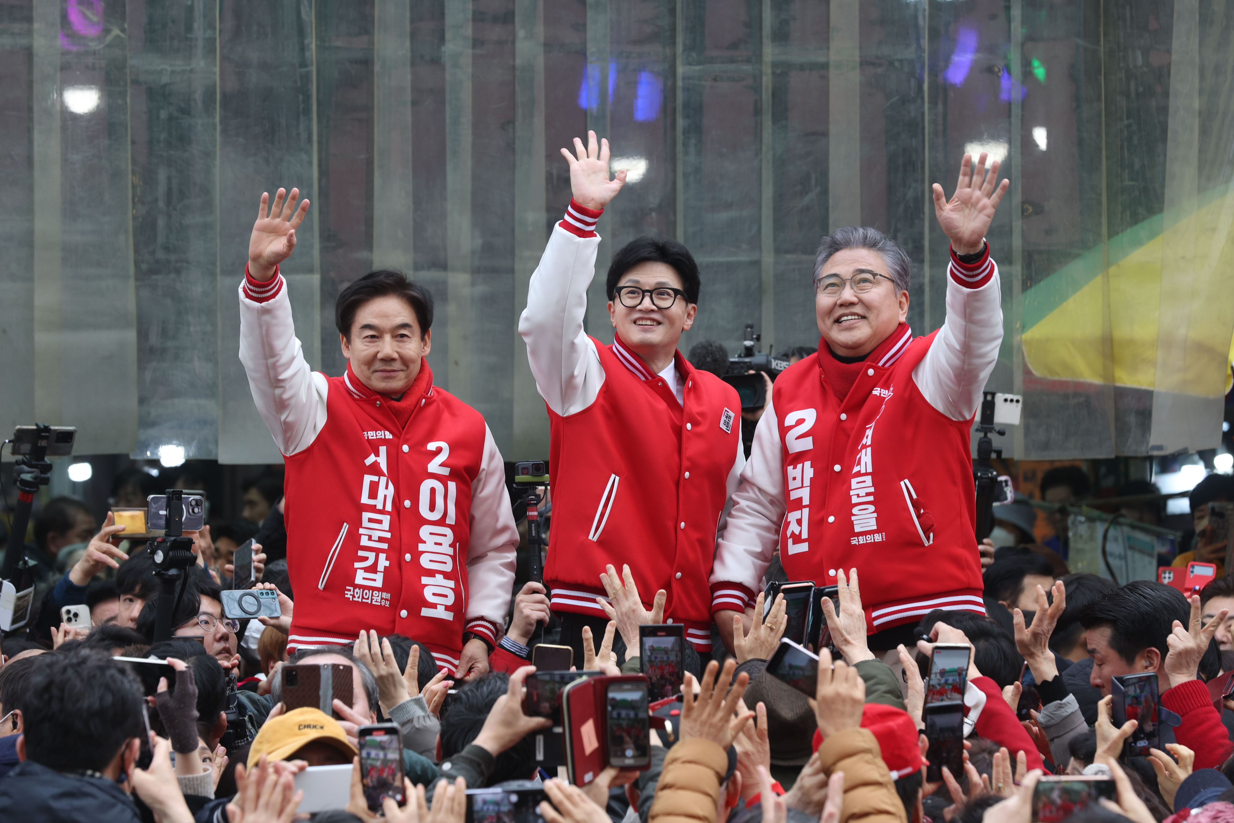 한동훈(가운데) 국민의힘 총괄선대위원장과 이용호(서울 서대문갑)·박진(서울 서대문을) 후보가 19일 서울 서대문구 인왕시장에서 지지자들에게 인사하고 있다. 왼쪽부터 이 후보, 한 위원장, 박 후보. 뉴스1