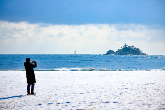 20일 오전 강원 속초 청호해변 백사장이 밤사이 내린 눈으로 이국적인 풍경을 자아내고 있다.  2024.3.20   속초시 제공