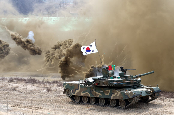 20일 경기도 연천군에서 실시된 한미연합 제병협동 도하훈련에서 육군 K1E1 전차가 한미 장병이 설치한 부교를 건넌 뒤 연막탄을 터뜨리고 있다.  이번 훈련에는 육군 5공병여단과 5기갑여단, 미2사단/한미연합사단 장병이 참가했다. 2024.3.20  연합뉴스