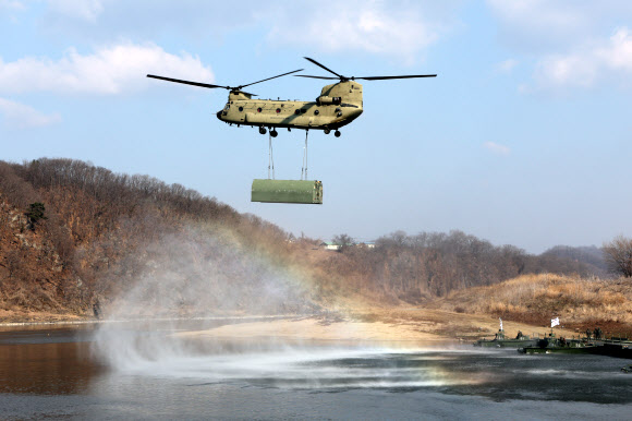 20일 경기도 연천군에서 실시된 한미연합 제병협동 도하훈련에서 미군 시누크(CH-47D) 헬기가 부교를 공중 수송하고 있다.  이번 훈련에는 육군 5공병여단과 5기갑여단, 미2사단/한미연합사단 장병이 참가했다. 2024.3.20  연합뉴스