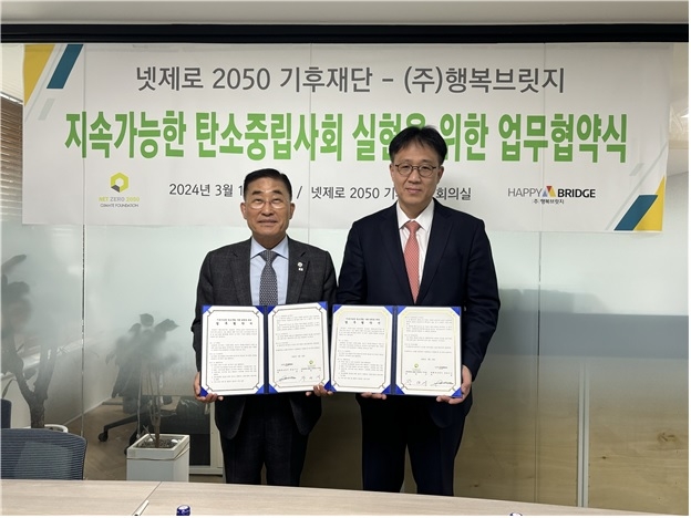 넷제로 2050 기후재단 장대식(왼쪽) 이사장과 행복브릿지 박남 대표가 지속가능한 탄소중립 사회 실현을 위한 업무협약을 체결하고 기념사진을 찍고 있다.