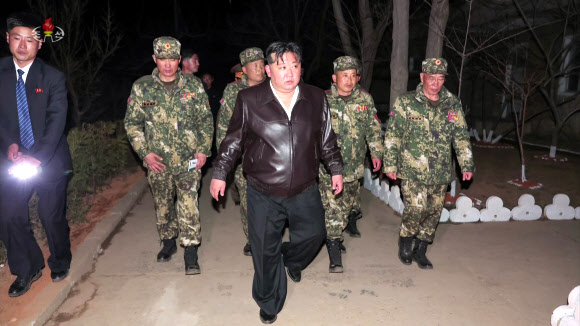 김정은 북한 국무위원장이 지난 24일 조선인민군 근위 서울류경수제105땅크(탱크)사단 지휘부와 직속 제1땅크장갑보병연대를 시찰했다고 조선중앙TV가 25일 보도했다. 북한의 한 경호원(왼쪽)이 플래시로 김 위원장의 앞길을 비추고 있다. 2024.3.25. 조선중앙TV 화면·연합뉴스