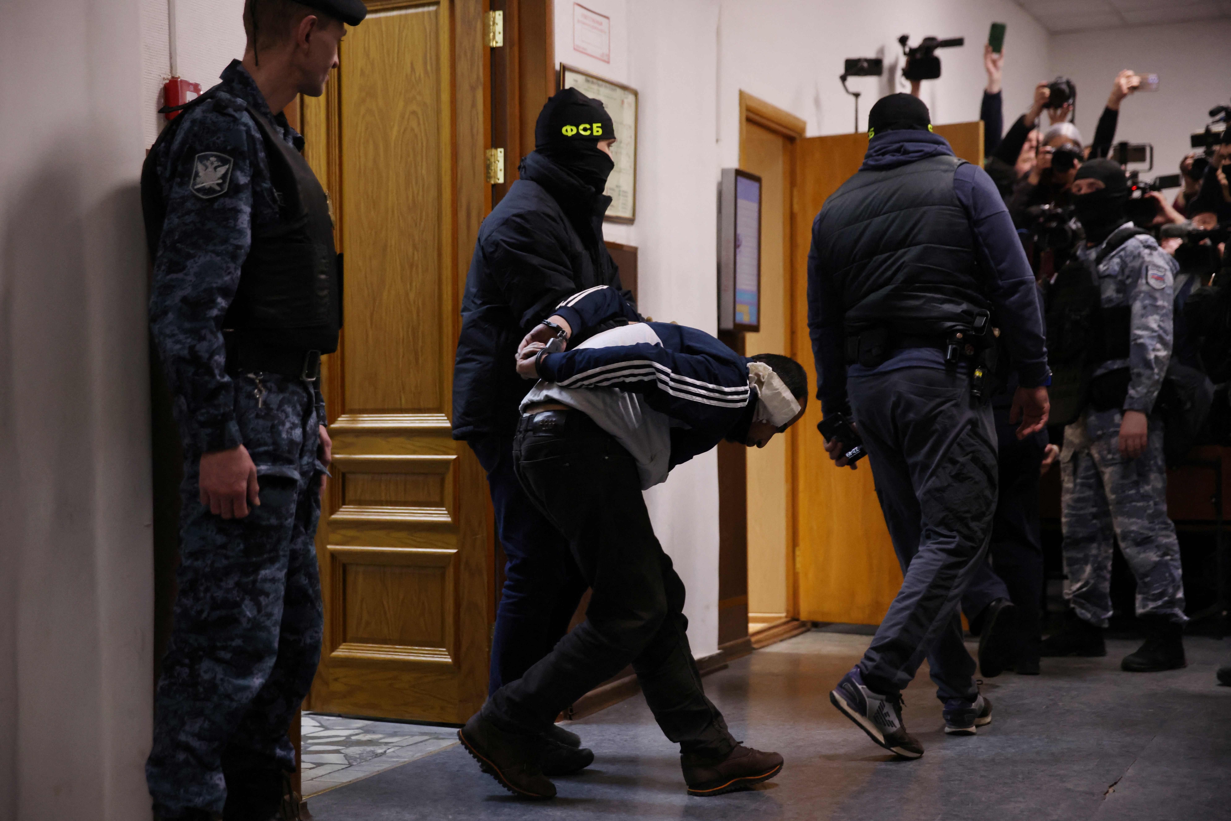 24일(현지시간) 러시아 모스크바 바스마니 지방법원에서 이슬람 극단주의 테러단체인 ‘이슬람국가 호라산’(ISIS-K)의 테러 모의에 가담한 남성 용의자(가운데)가 구속 전 심리를 받기 위해 집행관들에게 끌려가고 있다. 지난 22일 모스크바 크라스노고르스크의 ‘크로커스 시티홀’ 공연장에서 일어난 총격 사건으로 어린이 3명을 포함해 최소 137명이 사망했고, 핵심 가담자 4명을 포함한 11명이 검거돼 조사를 받고 있다. 모스크바 AFP 연합뉴스