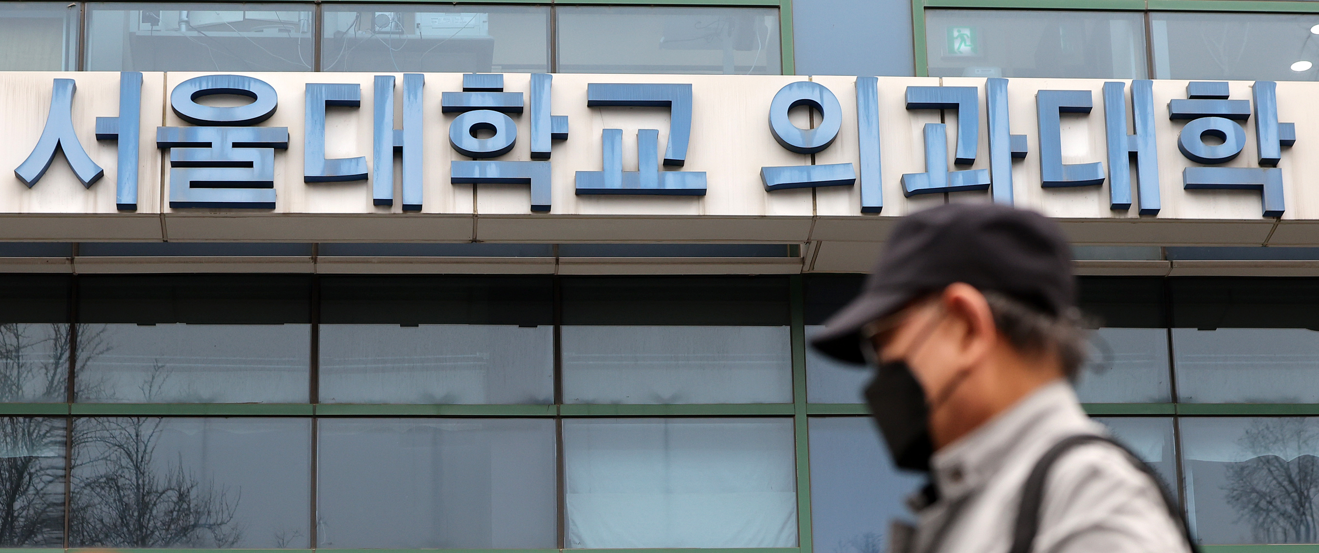 한 시민이 지난 19일 서울 종로구 연건동 서울대학교 의과대학 앞을 지나고 있다. 뉴스1