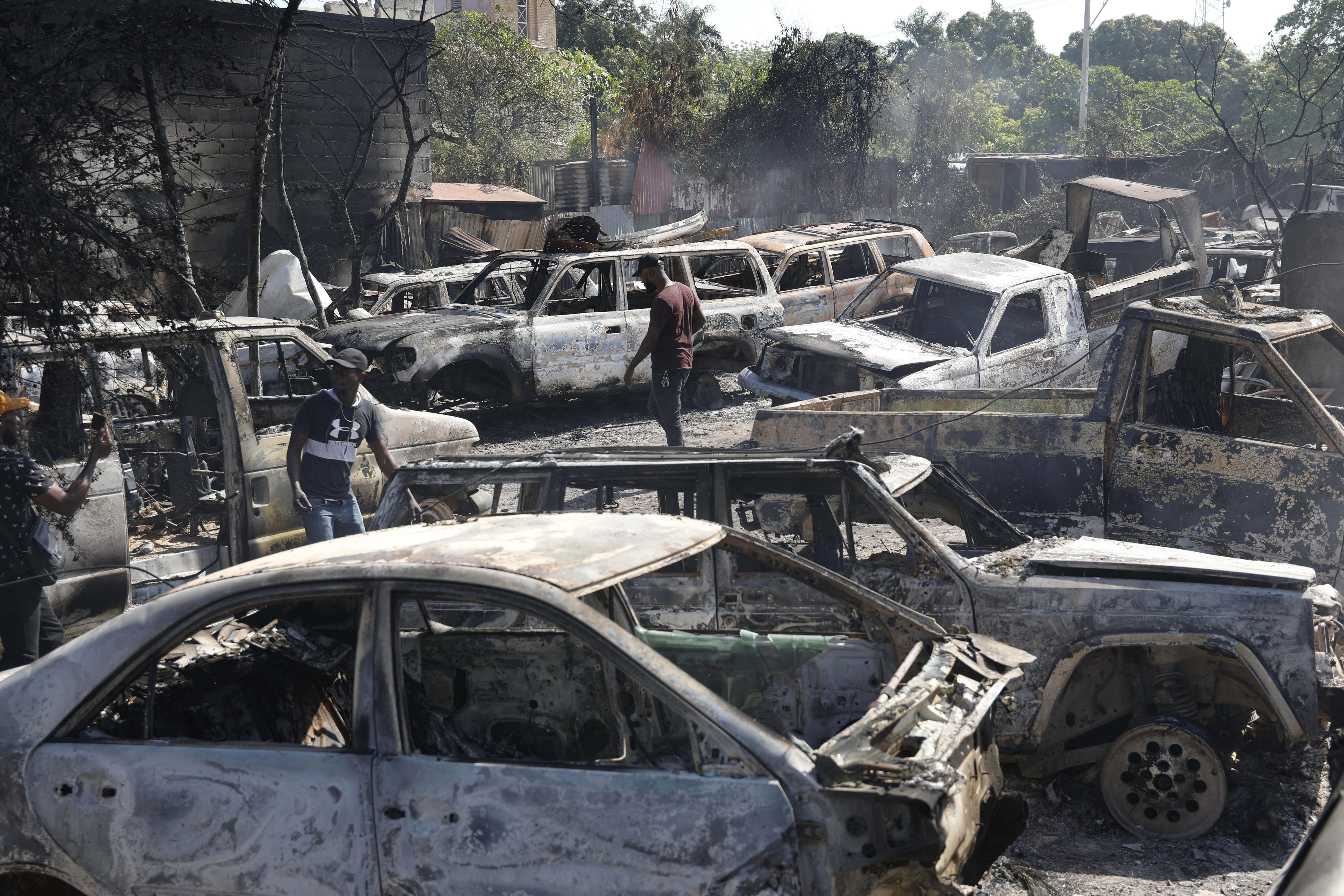 불에 탄 정비소, 쓸만한 물건 찾는 아이티 사람들