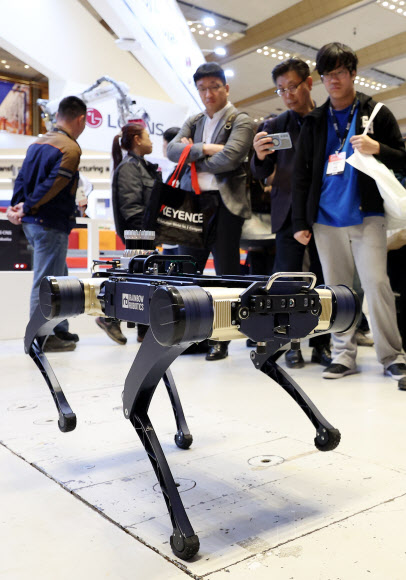 27일 서울 강남구 코엑스에서 열린  ‘스마트공장·자동화산업전 2024’에서 관람객이 레인보우로보틱스의 4족 보행로봇을 살펴보고 있다. 2024.3.27 연합뉴스