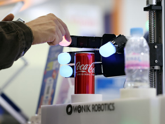 27일 서울 강남구 코엑스에서 열린  ‘스마트공장·자동화산업전 2024’에서 한 관람객이 한국전자통신연구원(ETRI) 개발한 전방위 촉각감지 4지 로봇핸드 기술을 살펴보고 있다. 사람 손가락 같은 강성(모듈러스)과 형상을 갖고 있어 단단한 물체부터 변형가능한 부드러운 물체까지 모두 유연하게 다룰 수 있는, 로봇 촉각 기능을 한 단계 끌어올린 혁신적 기술로 평가된다. 2024.3.27 연합뉴스