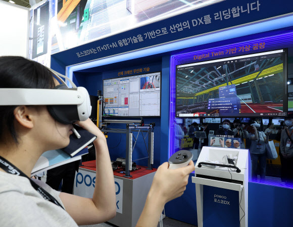27일 서울 강남구 코엑스에서 열린  ‘스마트공장·자동화산업전 2024’에서 포스코DX 부스를 찾은 관람객이 가상 공장을 체험하고 있다.  2024.3.27 연합뉴스