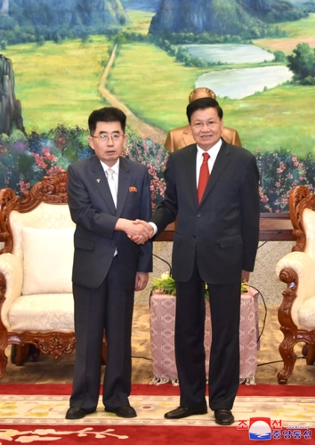 라오스를 방문 중인 북한 국제부장(왼쪽)이 지난 29일 통룬 시술릿 라오스 주석(오른쪽)을  만나 악수하고 있다. 조선중앙통신 연합뉴스